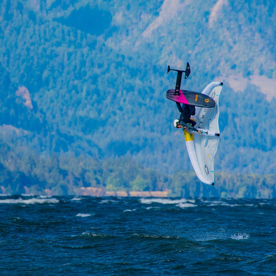 Rider en plein saut radicale sur la Duotone Sky Style SLS 2025, planche de wingfoil ultra réactive conçue pour le freestyle et le surf dans les vagues.