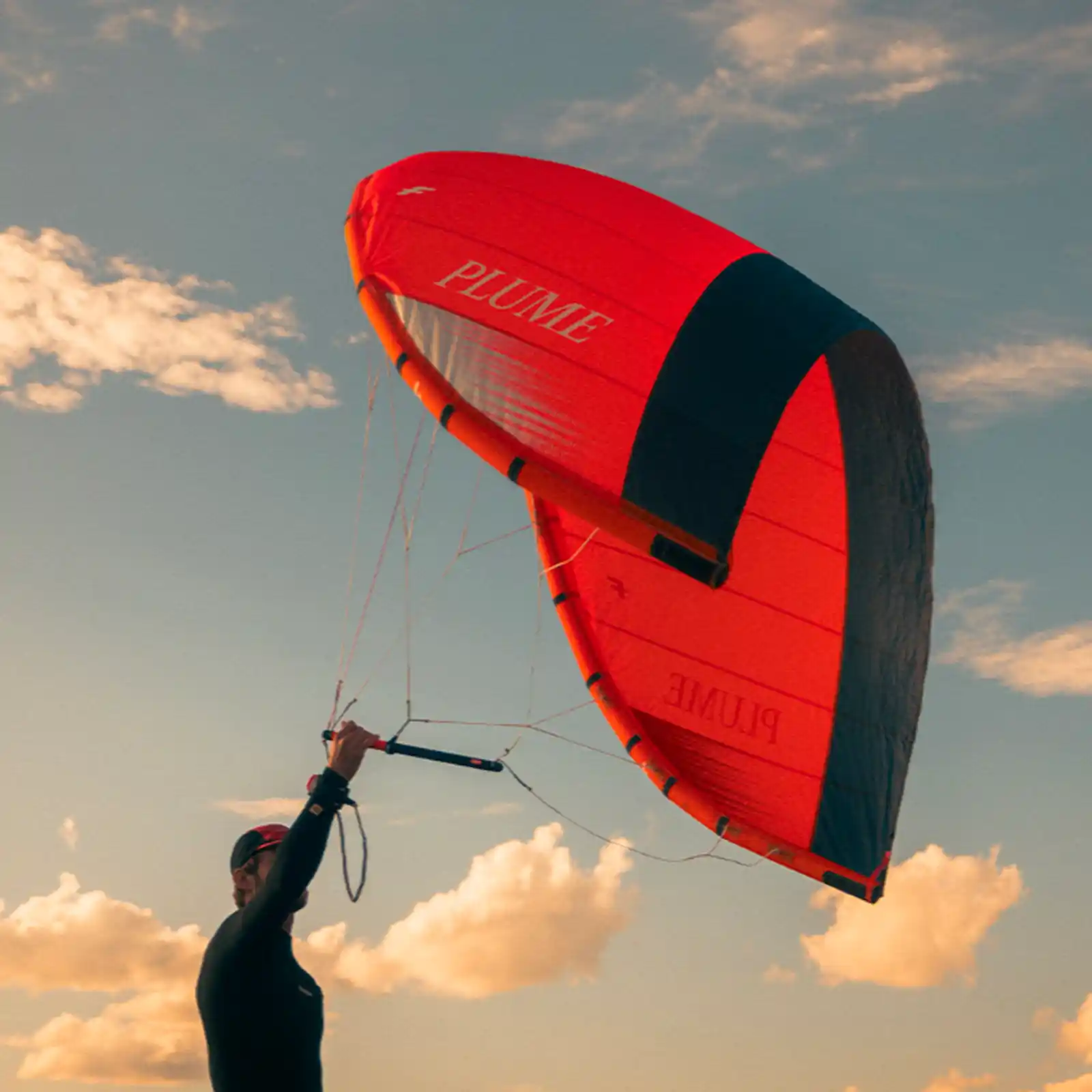 Rider en wingfoil sur la Slingshot Flowcraft V2, planche rouge et orange, testée en freeride sur plan d’eau turquoise.